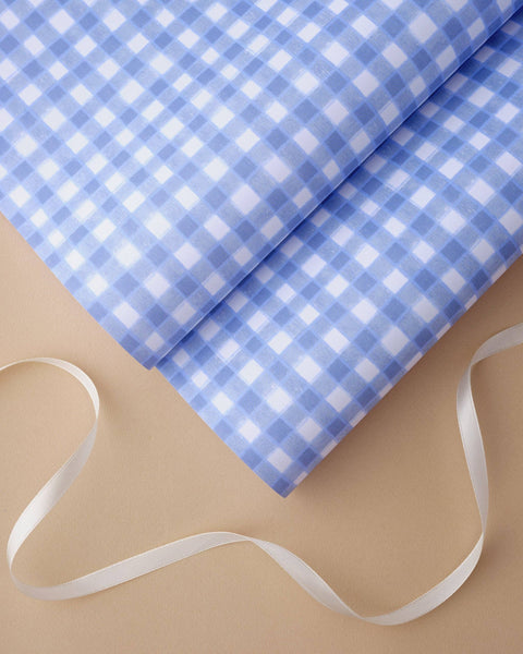 Blue and white checkered fabric with a white ribbon on a beige background