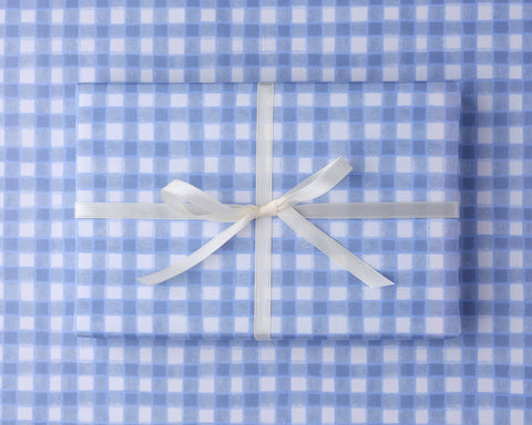 Gift wrapped in blue and white gingham paper with scissors and ribbon. Plastic free gift wrap, designed and printed in the UK. 