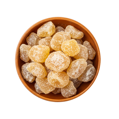 Brown bowl filled with crystallised ginger pieces on a white background