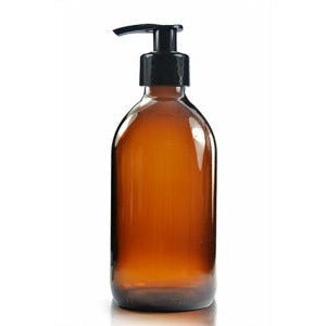 A brown amber glass bottle with a black pump dispenser, designed for refilling liquids such as shampoo or soap.